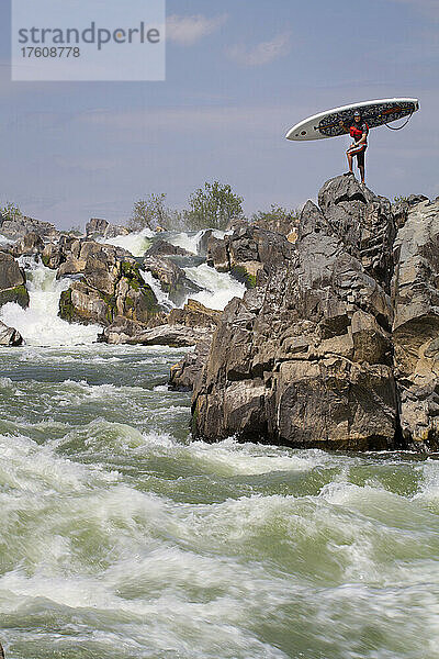 Ein Stand Up Paddle Boarder posiert auf den Felsen unterhalb von Great Falls; Potomac River  Maryland.