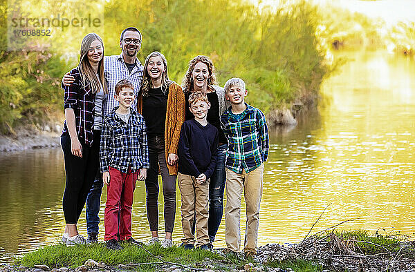 Siebenköpfige Familie  die für ein Familienporträt in einem Stadtpark im Herbst am Ufer des Wassers steht; Edmonton  Alberta  Kanada