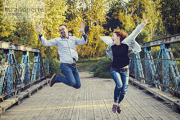 Älteres Ehepaar springt in einem Park in ausgelassener Feierlichkeit in die Luft; Edmonton  Alberta  Kanada