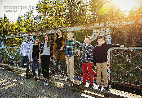 Siebenköpfige Familie auf einer Brücke für ein Familienporträt in einem Stadtpark im Herbst; Edmonton  Alberta  Kanada