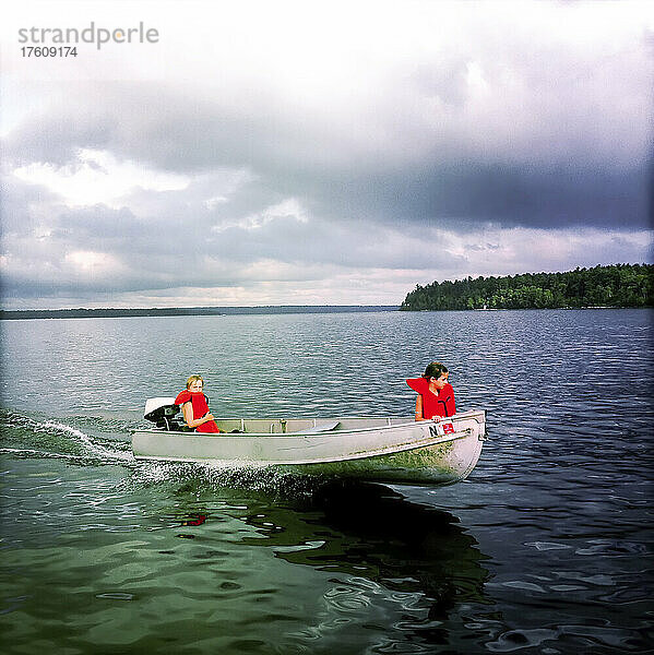 Sieben und acht Jahre alte Cousins fahren mit ihrem kleinen Aluminium-Motorboot über den Sebago Lake  Maine; Sebago Lake  Maine  Vereinigte Staaten.