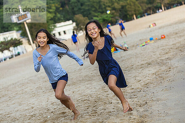 Zwei Schwestern beim Rennen am Repulse Bay Beach; Hongkong  China