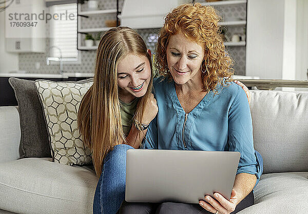 Mutter und Tochter schauen gemeinsam auf einen Laptop-Computer; Edmonton  Alberta  Kanada