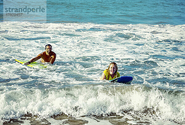 Glückliches Ehepaar spielt in den Wellen mit Bodyboards am D. T. Fleming Beach; Kapalua  Maui  Hawaii  Vereinigte Staaten von Amerika