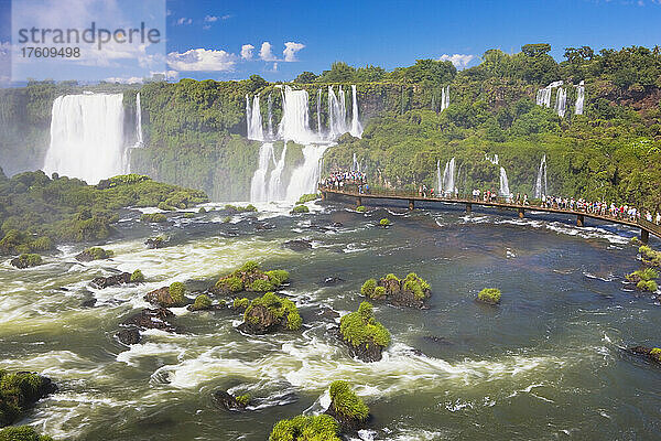 Touristen betrachten die Wasserfälle von einer erhöhten Plattform an den berühmten Iguazu-Fällen  Iguazu Falls National Park; Parana  Brasilien