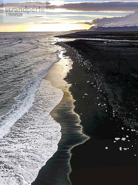 Luftaufnahme der schäumenden Brandung und des Eises aus der Gletscherlagune Jokulsarlon  das an einen schwarzen Sandstrand gespült wird; Jokulsarlon  Vatnajökull-Nationalpark  Island