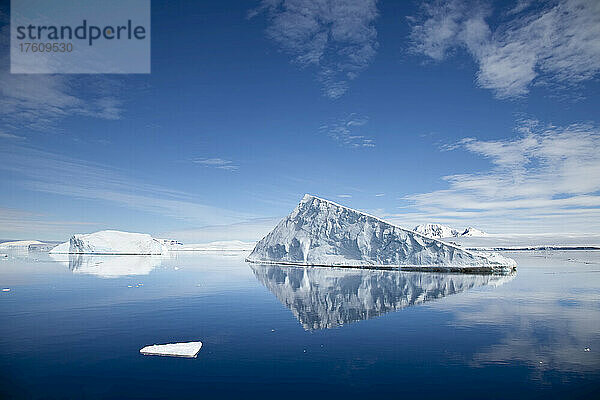 Ein Eisberg  der sich im ruhigen Polarwasser spiegelt.