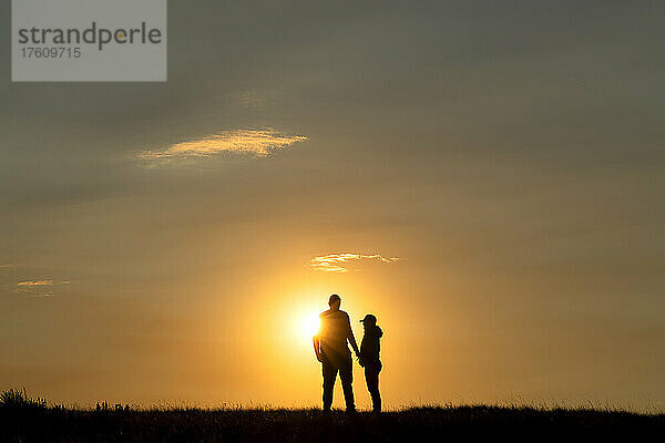 Silhouette eines verliebten Paares  während die Sonne hinter ihnen untergeht  Grasslands National Park; Val Marie  Saskatchewan  Kanada