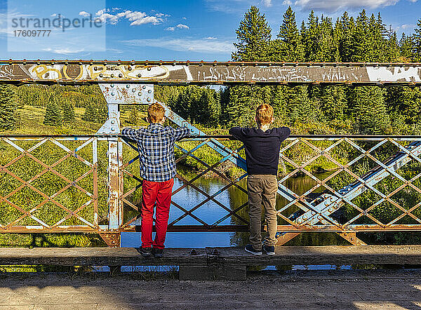 Zwei Jungen schauen von einer Parkbrücke auf einen darunter liegenden Bach; Edmonton  Alberta  Kanada