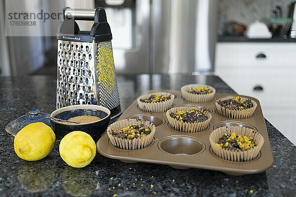 Backen von Muffins mit Zitronenschale und frischen Zitronen mit Reibe auf der Küchentheke; Kelowna  British Columbia  Kanada