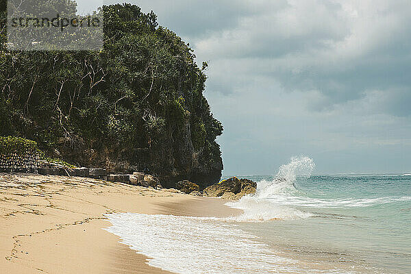 Wellen brechen gegen die Felsen und die Brandung rollt auf den Sand am Geger Beach im Feriengebiet Nusa Dua; Geger Beach  Badung  Bali  Indonesien