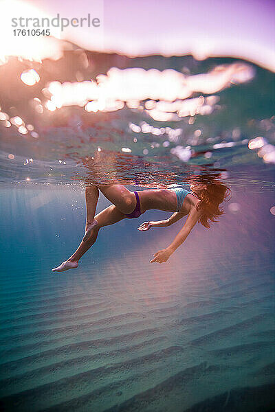 Eine Frau schwimmt in den klaren Gewässern von Baja.