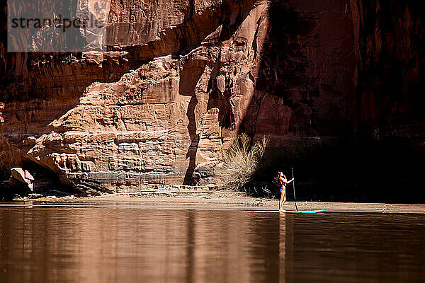 Eine junge Frau paddelt auf dem Colorado River in Utah.