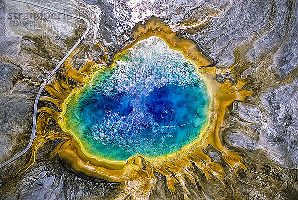 Die Grand Prismatic Spring ist eines der größten und schönsten Beispiele für eine häufige hydrothermale Erscheinung im Yellowstone-Nationalpark und eine der größten heißen Quellen in den Vereinigten Staaten. Die prismatischen  farbenfrohen Merkmale stammen aus mehreren Quellen; das tiefe Blau in der Mitte ist das klare  überhitzte Wasser  das aus der unterirdischen Wärmequelle nach oben zirkuliert  und zeigt ein Paar Konvektionsströme  wie ein Paar Augen. Wenn das Wasser an den Rändern des Beckens und auf den Sinterterrassen abkühlt  erzeugen Bakterien und Algen den Regenbogen der Farben. Diese heiße Quelle wurde in Osborne Russells Journal of a Trapper ausdrücklich unter dem Namen Boiling Lake erwähnt  der offenbar von Pelztierjägern aus den Rocky Mountains in den 1830er Jahren vergeben wurde. Sie befindet sich im Yellowstone-Nationalpark  Wyoming  Vereinigte Staaten von Amerika