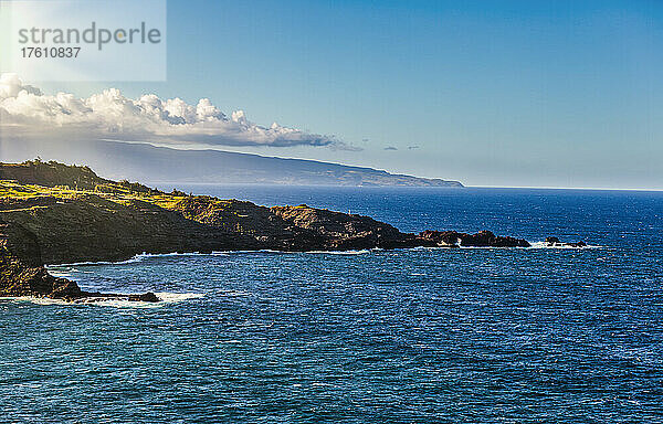Blick auf den Ozean und den Horizont vor einem blauen Himmel mit der zerklüfteten  felsigen Küste von Nordwest-Maui mit der Insel Lanai im Hintergrund; Maui  Hawaii  Vereinigte Staaten von Amerika