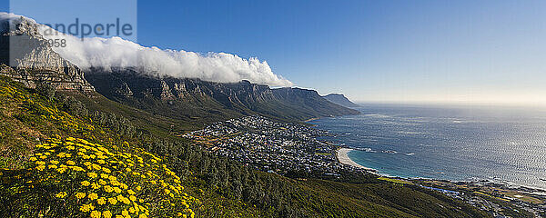 Wolkenformation mit Tischtuch-Effekt über der Bergkette der Zwölf Apostel mit Blick auf die Skyline von Kapstadt und die Camps Bay an der Atlantikküste; Kapstadt  Provinz Westkap  Südafrika