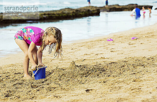 Ein junges Mädchen spielt mit einem Eimer im Sand am Strand von Ka'anapali; Ka'anapali  Maui  Hawaii  Vereinigte Staaten von Amerika