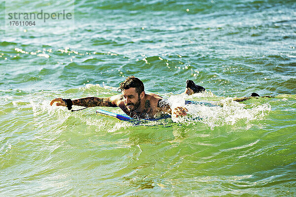 Ein Mann paddelt im Wasser auf einem Bodyboard am D. T. Fleming Beach; Kapalua  Maui  Hawaii  Vereinigte Staaten von Amerika