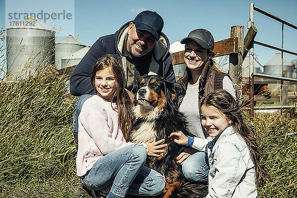 Familienporträt der Eltern mit ihren beiden kleinen Mädchen  die mit dem Familienhund auf ihrer Farm posieren; Alcomdale  Alberta  Kanada