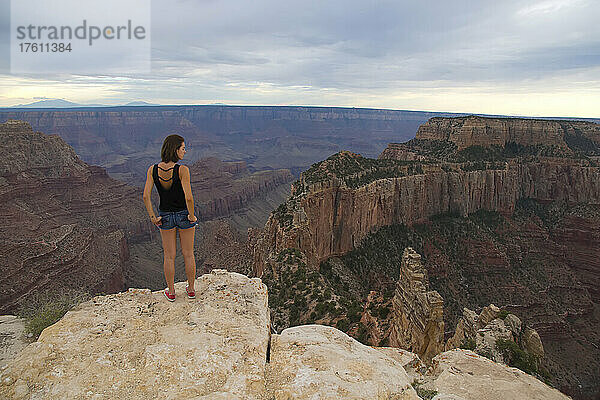 Eine junge Frau bewundert die Landschaft des Grand Canyon.