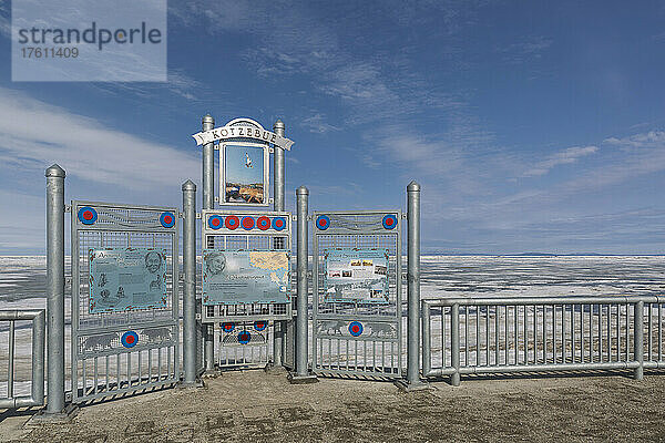 Hinweisschild am Ufer des Kotzebue Sound mit schmelzendem Schnee und Eis im Frühling und den Baird Mountains in der Ferne; Kotzebue  Nordwest-Alaska  Alaska  Vereinigte Staaten von Amerika