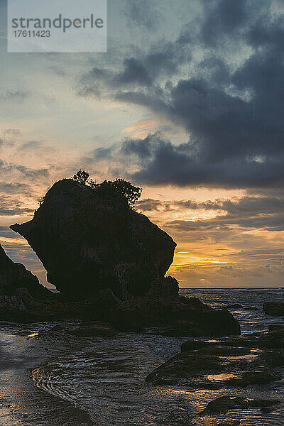 Silhouette einer großen Felsformation und der Küstenlinie des Diamond Beach in der Dämmerung  Nusa Penida  Bali  Indonesien; Nusa Penida  Bali  Indonesien