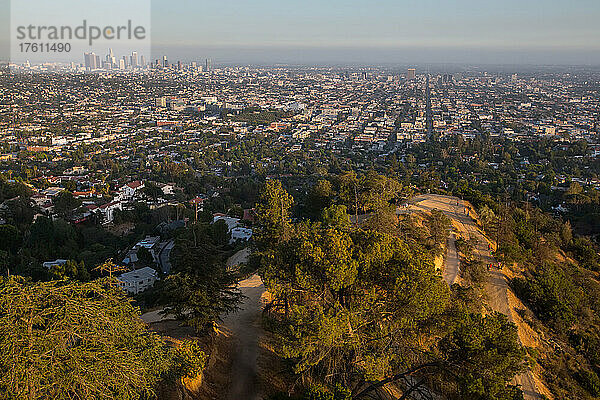 Menschen wandern auf dem Griffith Park Trail mit der Skyline von Los Angeles im Hintergrund.