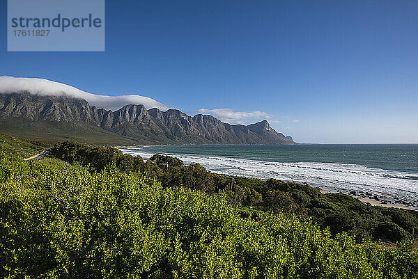 Blick auf den Strand von Kogel Bay entlang der malerischen R44-Route mit den Kogelbergen in der Ferne; Kogel Bay  Kapstadt  Westkap  Südafrika