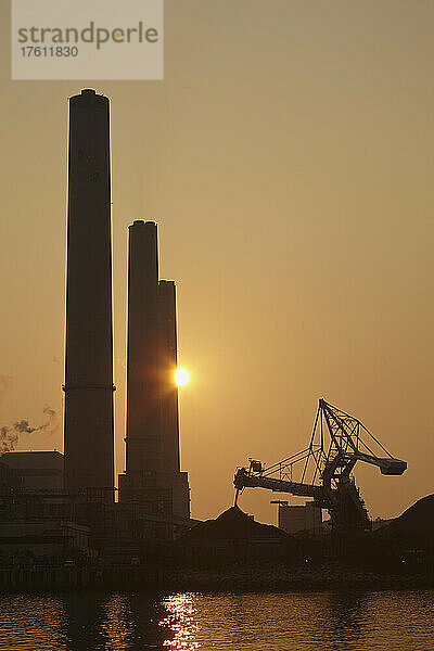 Silhouette eines Kohlekraftwerks bei Sonnenuntergang  Lamma Island  Hongkong; Yung Shue Wan  Lamma Island  Hongkong  China.