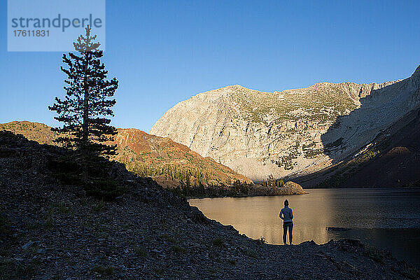 Ein Besucher des Yosemite National Park steht am felsigen Ufer des Ellery Lake; Yosemite National Park  Kalifornien