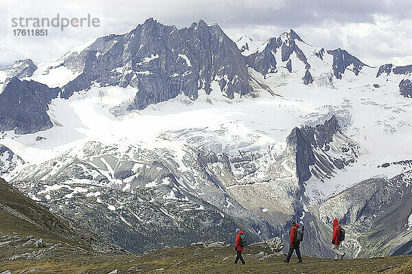 Wanderer auf einer Kammlinie mit schneebedeckten Gipfeln im Hintergrund; Adamants Mountain Range  British Columbia  Kanada