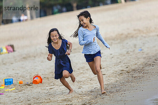 Zwei Schwestern beim Rennen am Repulse Bay Beach; Hongkong  China