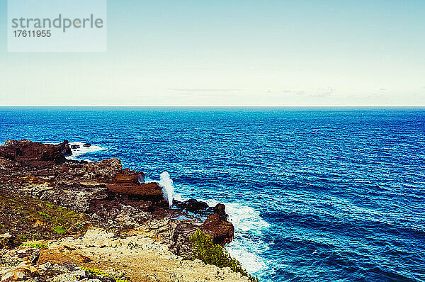 Blick auf den Ozean und das Nakalele Blowhole vor blauem Himmel mit der zerklüfteten  felsigen Küstenlinie im Vordergrund; Maui  Hawaii  Vereinigte Staaten von Amerika