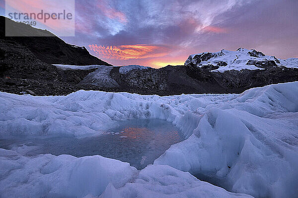 Gefrorene Wasserlache auf dem Eis des Gornergletschers bei Sonnenaufgang; Gornergrat  Zermatt  Schweiz.
