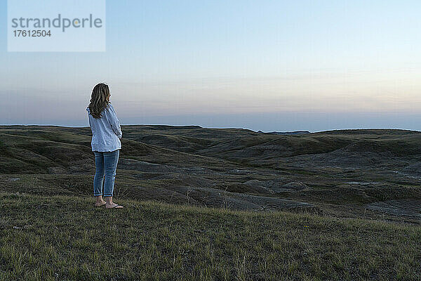 Frau betrachtet den Sonnenuntergang über den Prärien von Saskatchewan im Grasslands National Park; Saskatchewan  Kanada