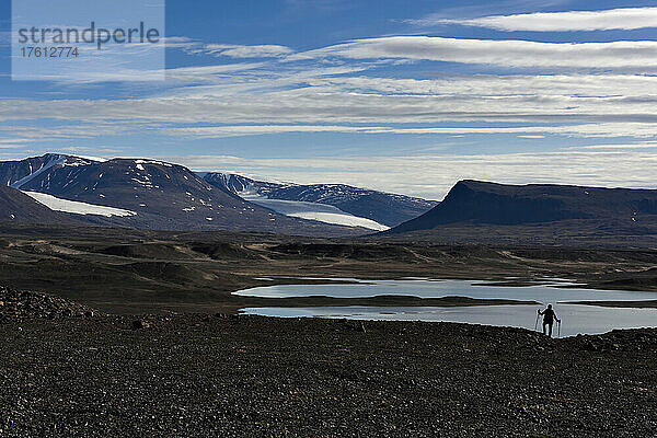 Ein Expeditionsmitglied  das auf der Suche nach Höhlen zum Zweck der Erforschung des Klimawandels ist  genießt den Blick auf das Vandredalen; Grönland.