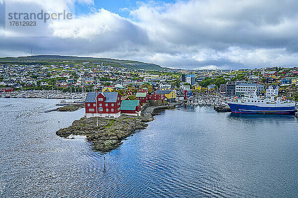 Überblick über den Hafen von Torshavn  der Hauptstadt des autonomen dänischen Territoriums der Färöer auf der Insel Streymoy  mit den historischen Parlamentsgebäuden auf dem Felsvorsprung im alten Stadtzentrum von Tinganes; Färöer Inseln