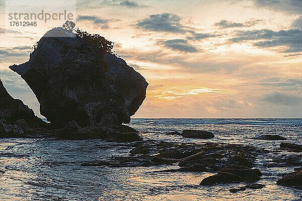 Silhouette einer großen Felsformation und der Küstenlinie des Diamond Beach in der Dämmerung  Nusa Penida  Bali  Indonesien; Nusa Penida  Bali  Indonesien