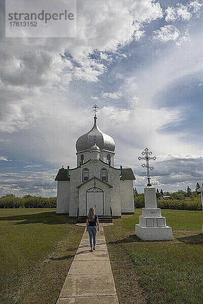 Frau  die auf die Türen der orthodoxen Kirche Saints Peter and Paul im ländlichen Saskatchewan zugeht; Krydor  Saskatchewan  Kanada