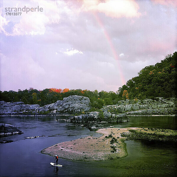 Ein elfjähriger Junge auf seinem Stand Up Paddle Board und Regenbogen auf dem Potomac River; Potomac  Maryland.