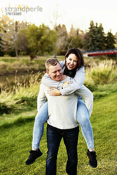 Porträt eines Paares im mittleren Erwachsenenalter  das sich im Herbst in einem Park amüsiert; St. Albert  Alberta  Kanada
