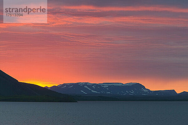 Mitternachtssonne (Sonnenuntergang um 12.15 Uhr) über dem Myvatn-See  mit einer Silhouette des Vulkans Vindbelgjarfjall; Island