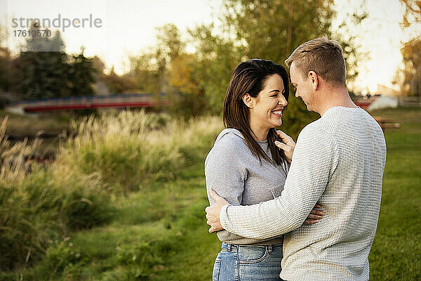 Ein mittleres erwachsenes Paar  das im Herbst in einem Park steht und miteinander spricht; St. Albert  Alberta  Kanada