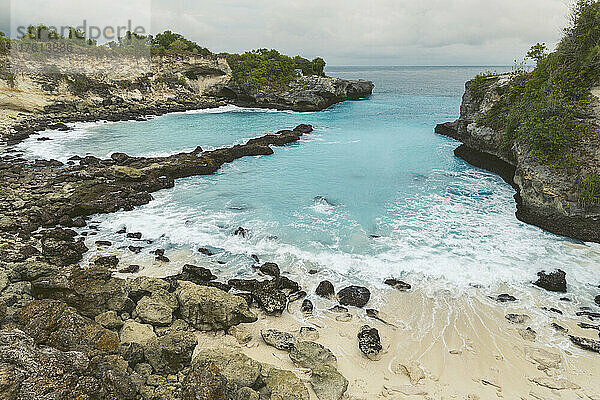 Die felsige Küste und die Strandpromenade des Ferienortes Lembongan am Rande des türkisfarbenen Wassers vor der Küste von Bali; Nusa-Inseln  Regentschaft Klungkung  Indonesien