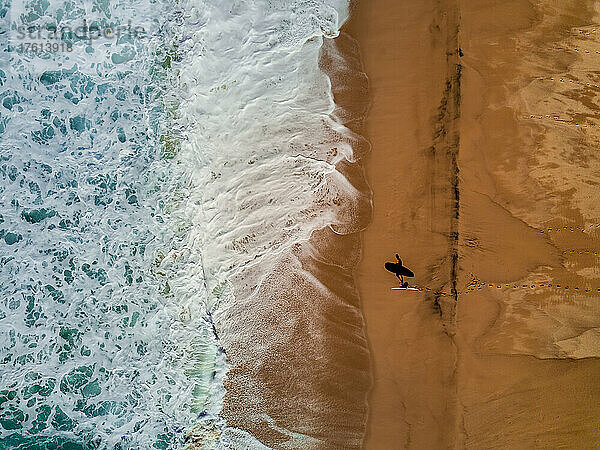 Ein Surfer und sein Schatten  aus der Luft gesehen.