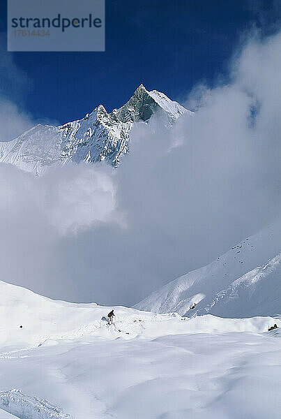 Mann beim Abstieg vom Annapurna-Basislager in die Wolken  Nepal; ANNAPURNA  NEPAL.