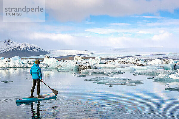 Ein Mann paddelt auf der Lagune des Jokulsarlon-Gletschers.