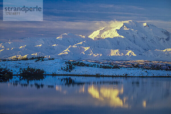 Warmes Morgenlicht auf dem schneebedeckten Denali Mountain  der sich im See darunter im Denali National Park spiegelt; Alaska  Vereinigte Staaten von Amerika