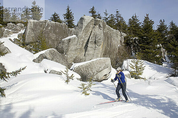 Eine Frau beim Skilanglauf vorbei an großen Felsen in West Virginia; Dolly Sods  West Virginia