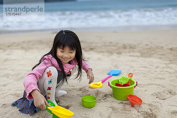 Junges Mädchen spielt am Strand mit buntem Strandspielzeug; Hongkong  China